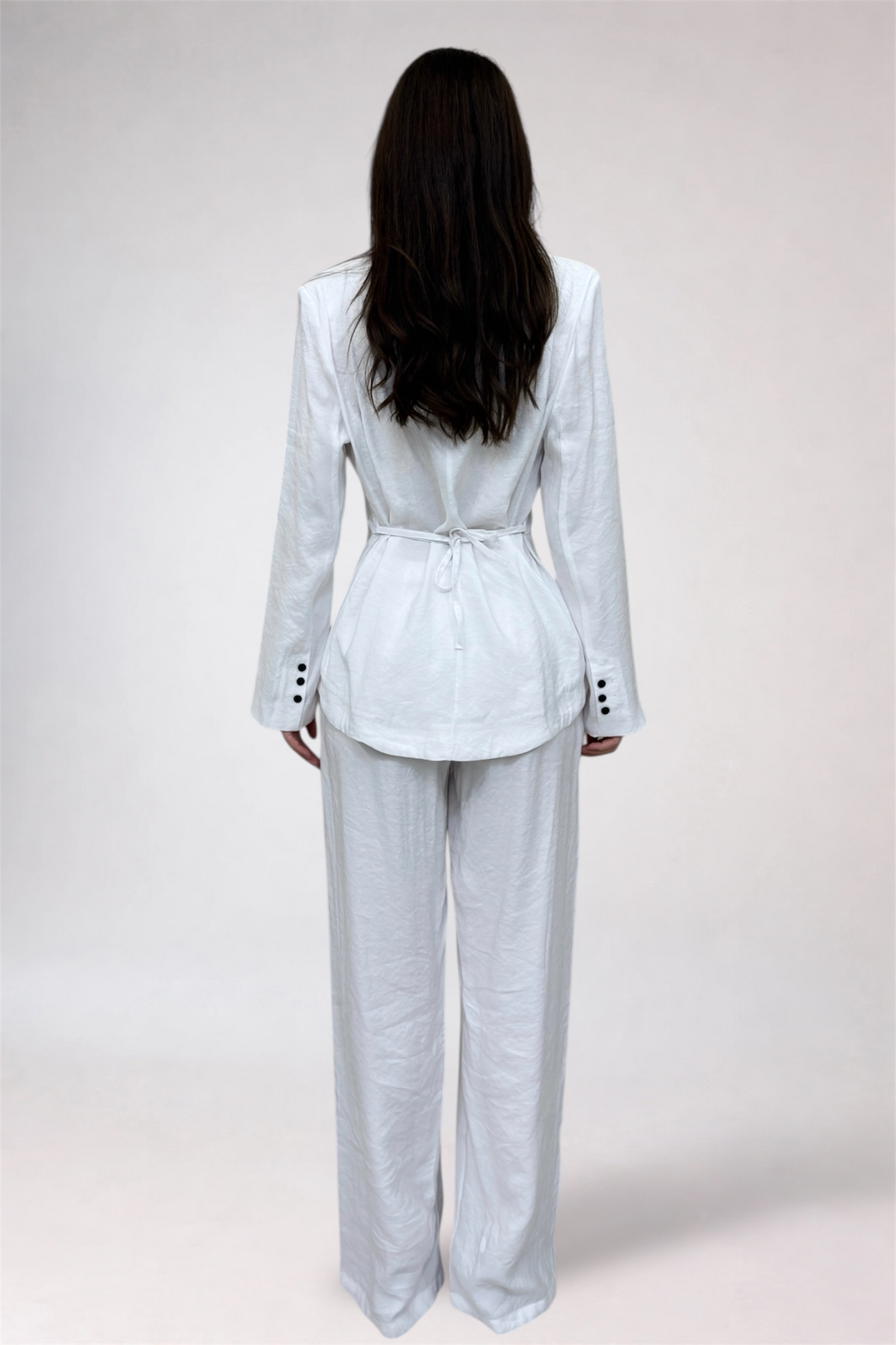 Person wearing a light gray suit on a white background