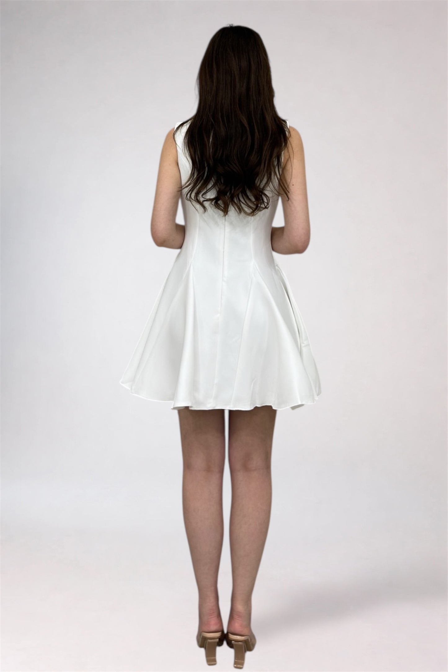 Woman wearing a white dress on a plain background