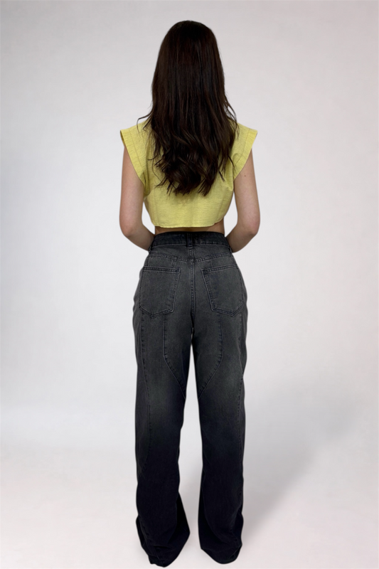 Person wearing a yellow top and dark pants on a white background