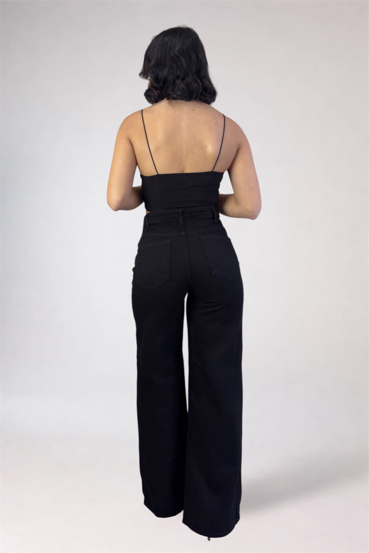 Person wearing a black jumpsuit on a white background