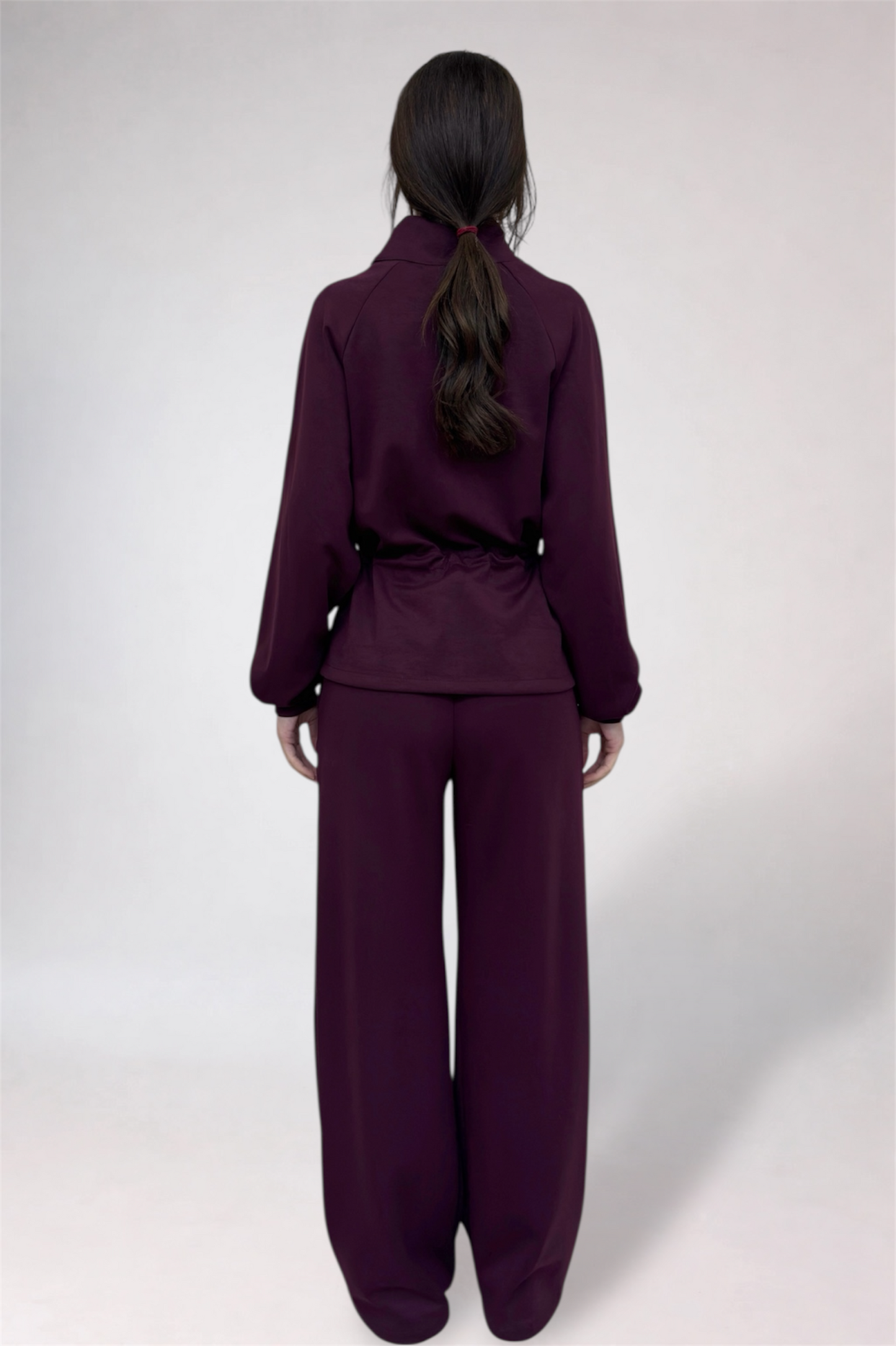 Person wearing a purple outfit on a white background