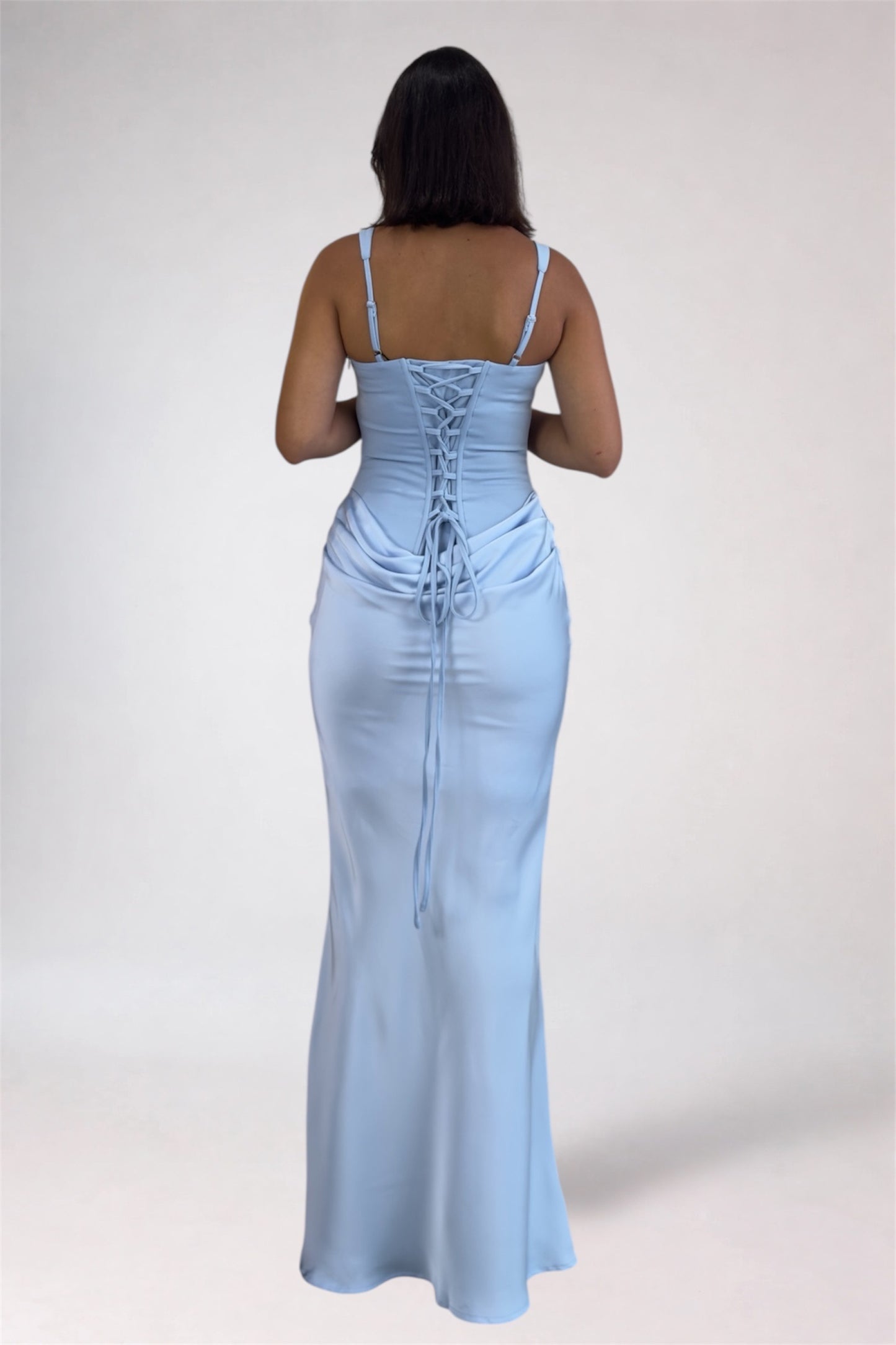 Light blue evening gown with lace-up back on a plain background