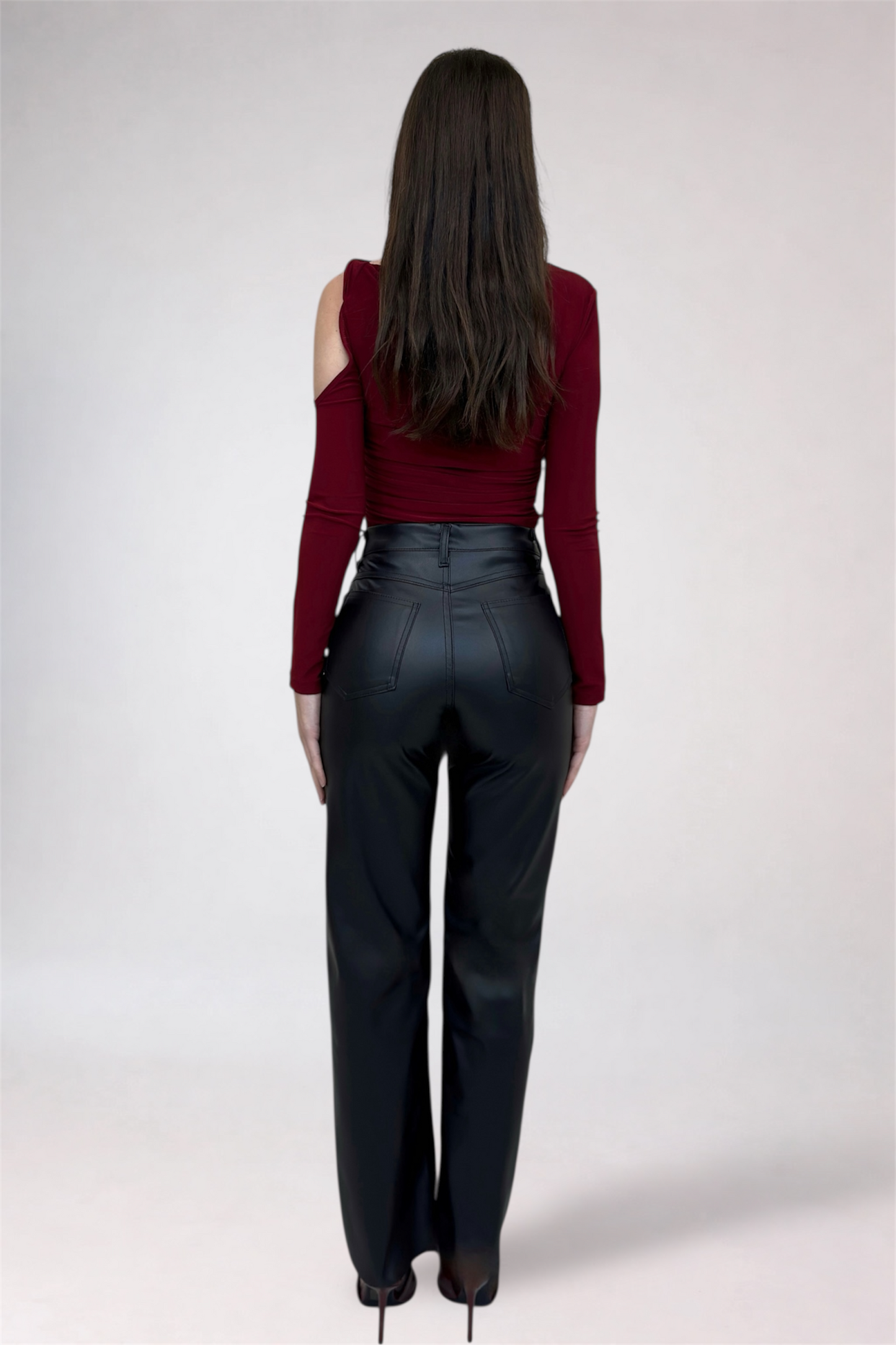 Person wearing a red top and black pants on a white background