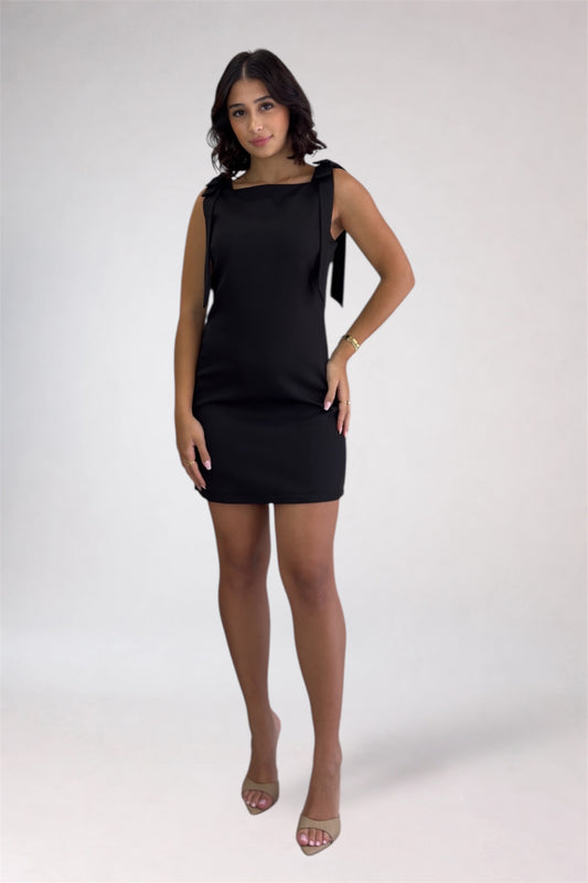 Woman wearing a black sleeveless dress on a white background