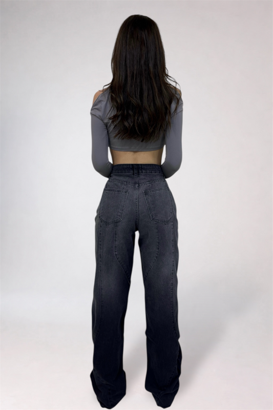 Person wearing a gray crop top and black high-waisted pants on a white background