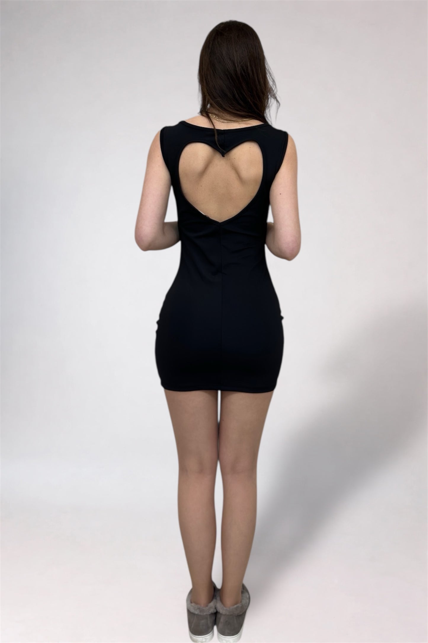 Black dress with open back worn by a person on a white background