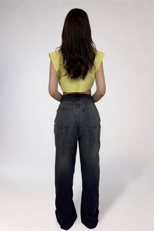 Person wearing a yellow top and dark pants on a white background