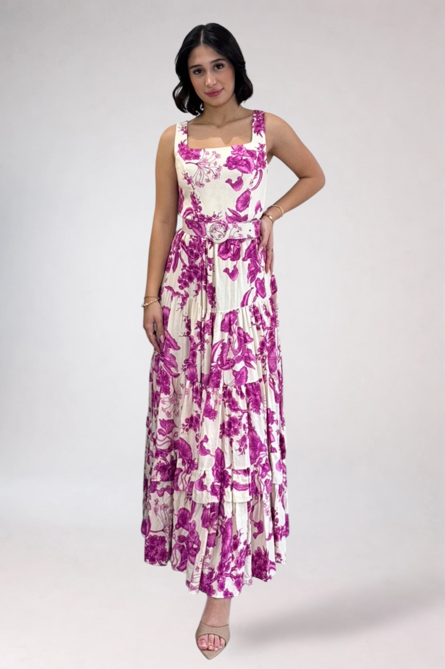 Woman wearing a floral dress with pink and purple flowers on a white background
