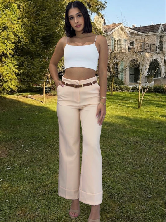 Woman wearing a light blue top and beige pants in nature