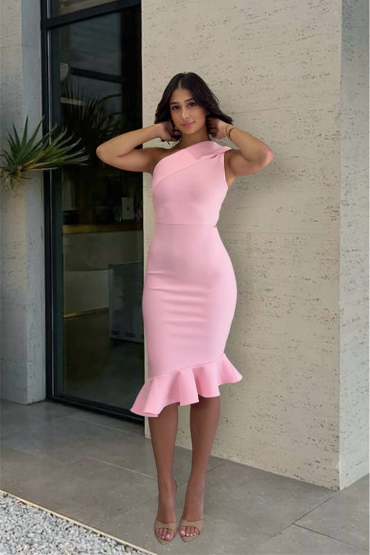 Woman in a pink one-shoulder dress standing against a building exterior.