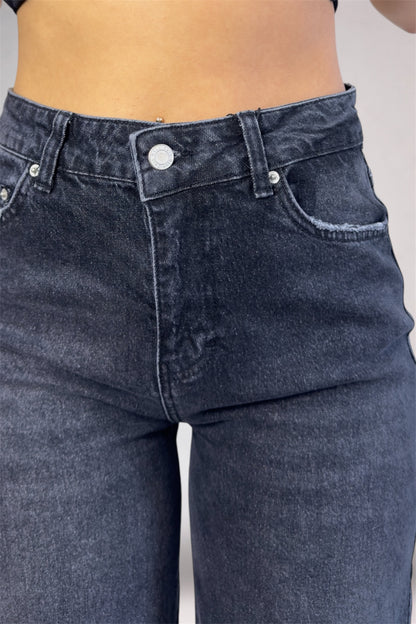 Close-up of dark blue jeans with a plain background
