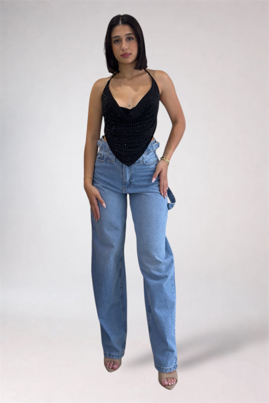 Woman wearing a black top and blue jeans on a white background