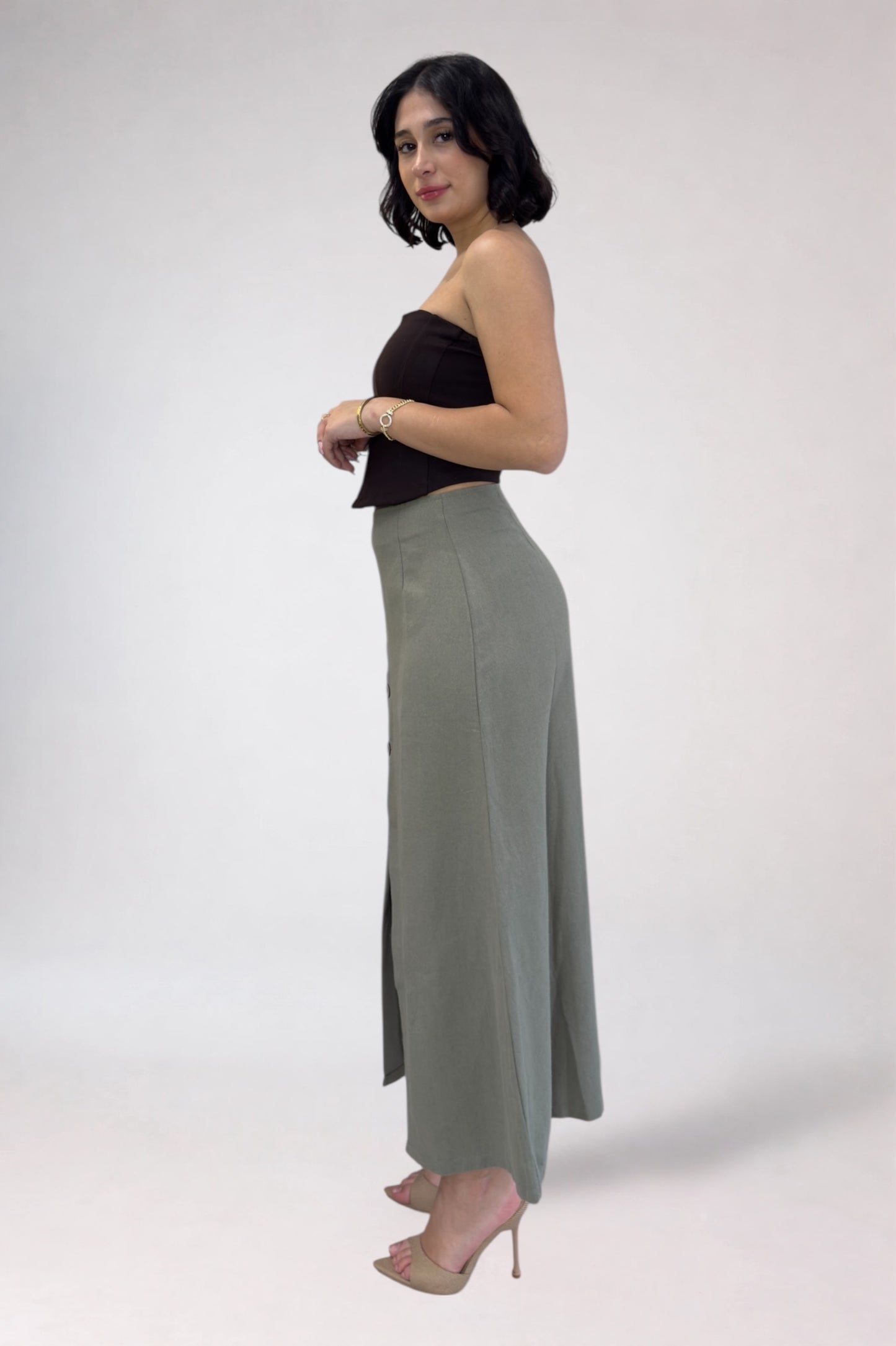 Woman wearing a black top and gray pants on a white background