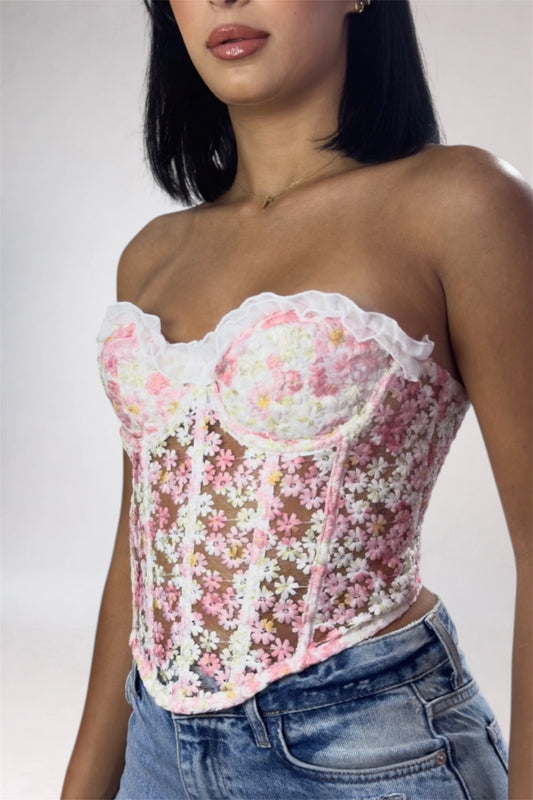 Woman wearing a floral lace top with a plain background