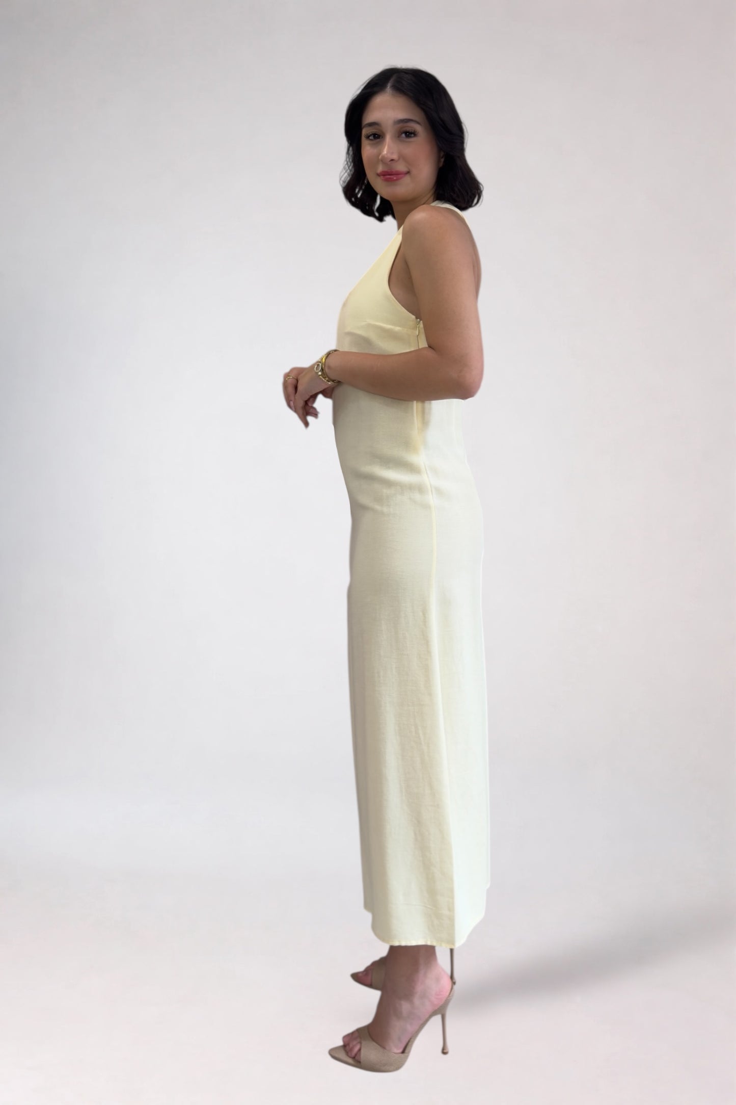 Woman wearing a light-colored jumpsuit on a white background