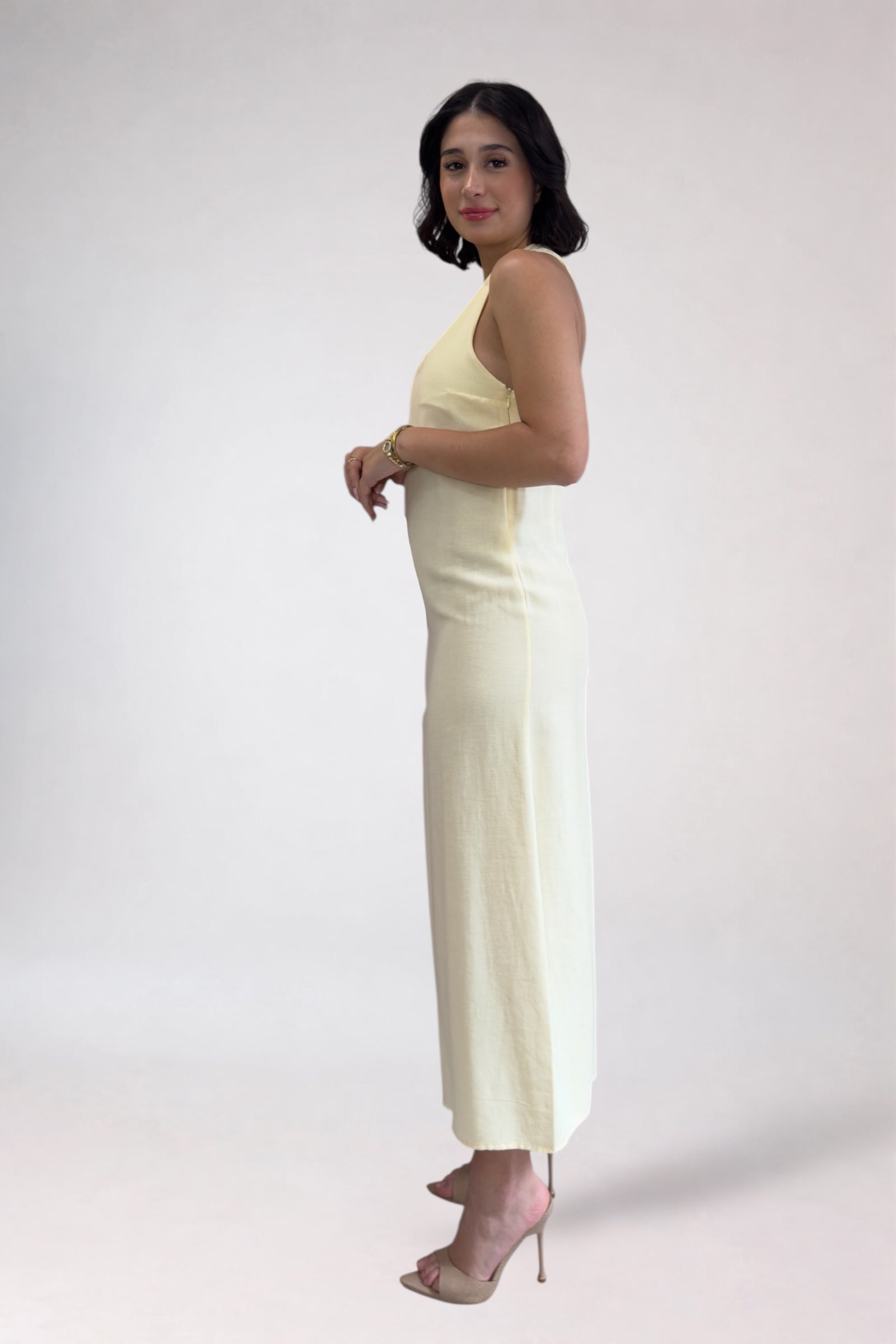 Woman wearing a light-colored jumpsuit on a white background