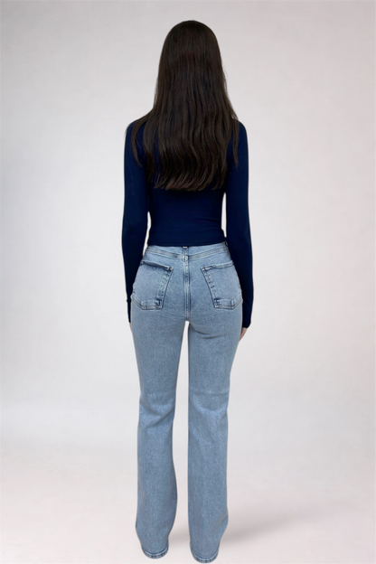 Person wearing blue jeans and a dark top on a white background