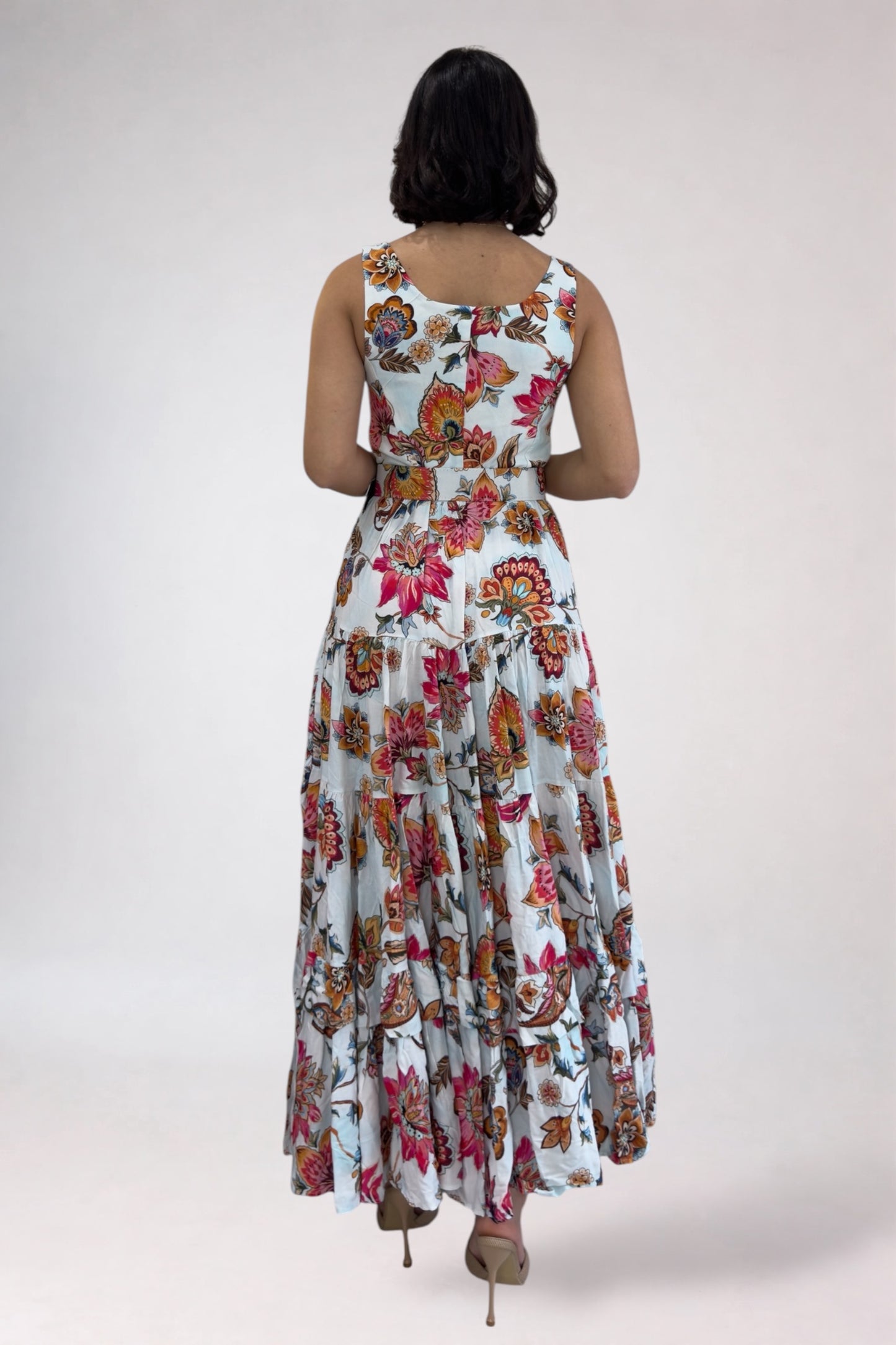 Woman wearing a floral dress from behind on a plain background