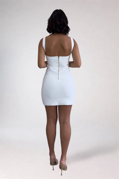 Person wearing a white dress with a gold zipper on a plain background