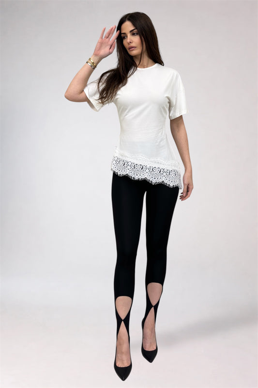 Woman wearing a white top with lace details and black leggings on a white background
