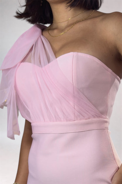 Pink one-shoulder dress with a sheer overlay on a plain background
