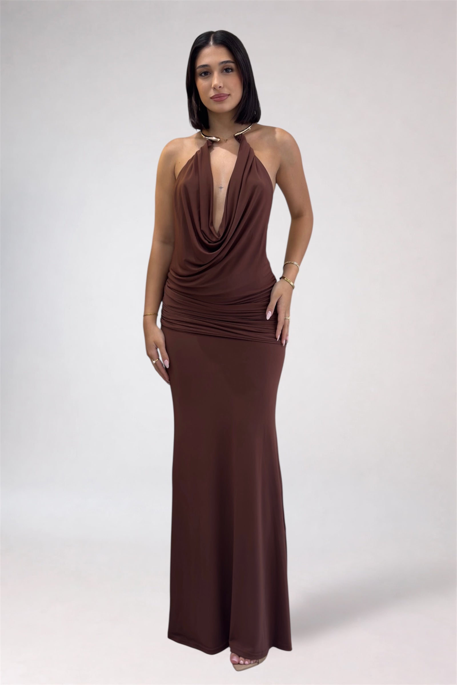 Woman wearing a brown halter neck gown on a white background