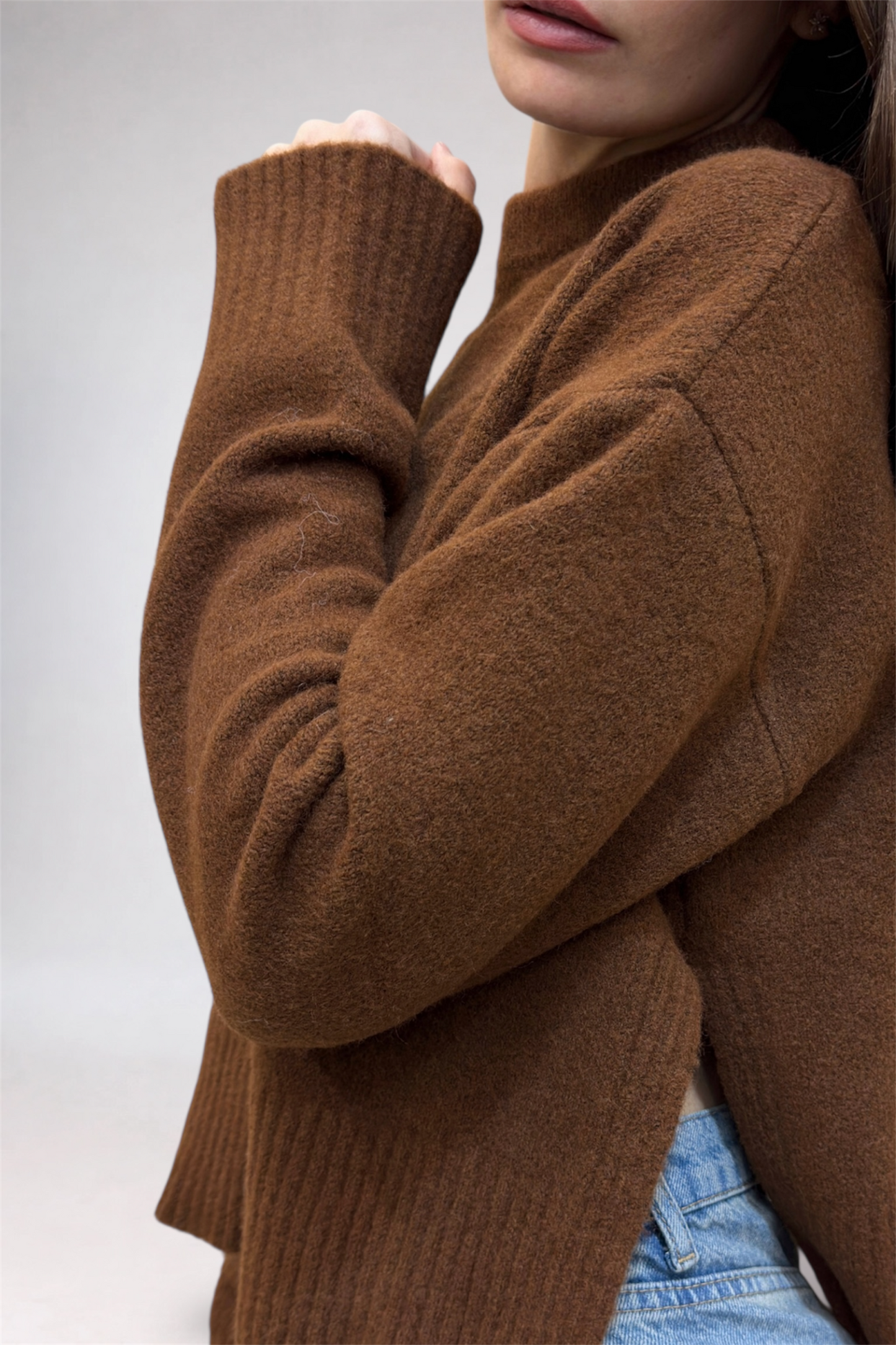 Brown sweater worn by a person on a light gray background