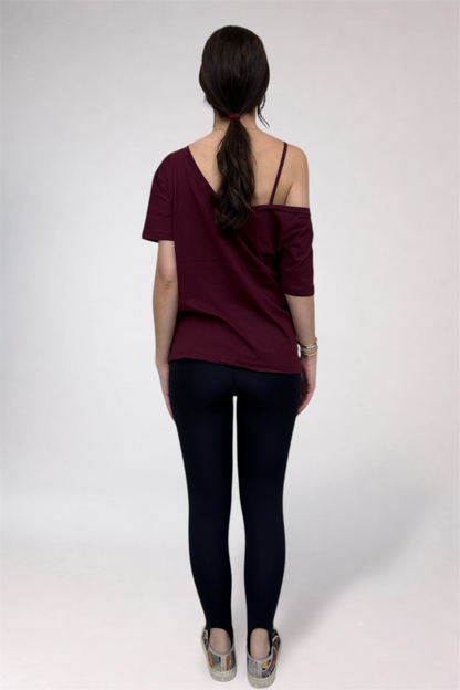 Woman wearing a burgundy top and black pants on a white background