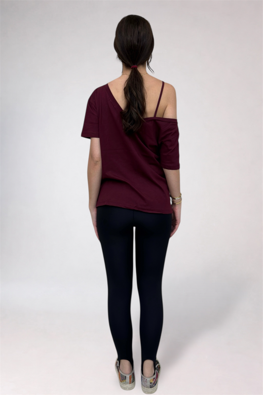 Woman wearing a burgundy top and black pants on a white background