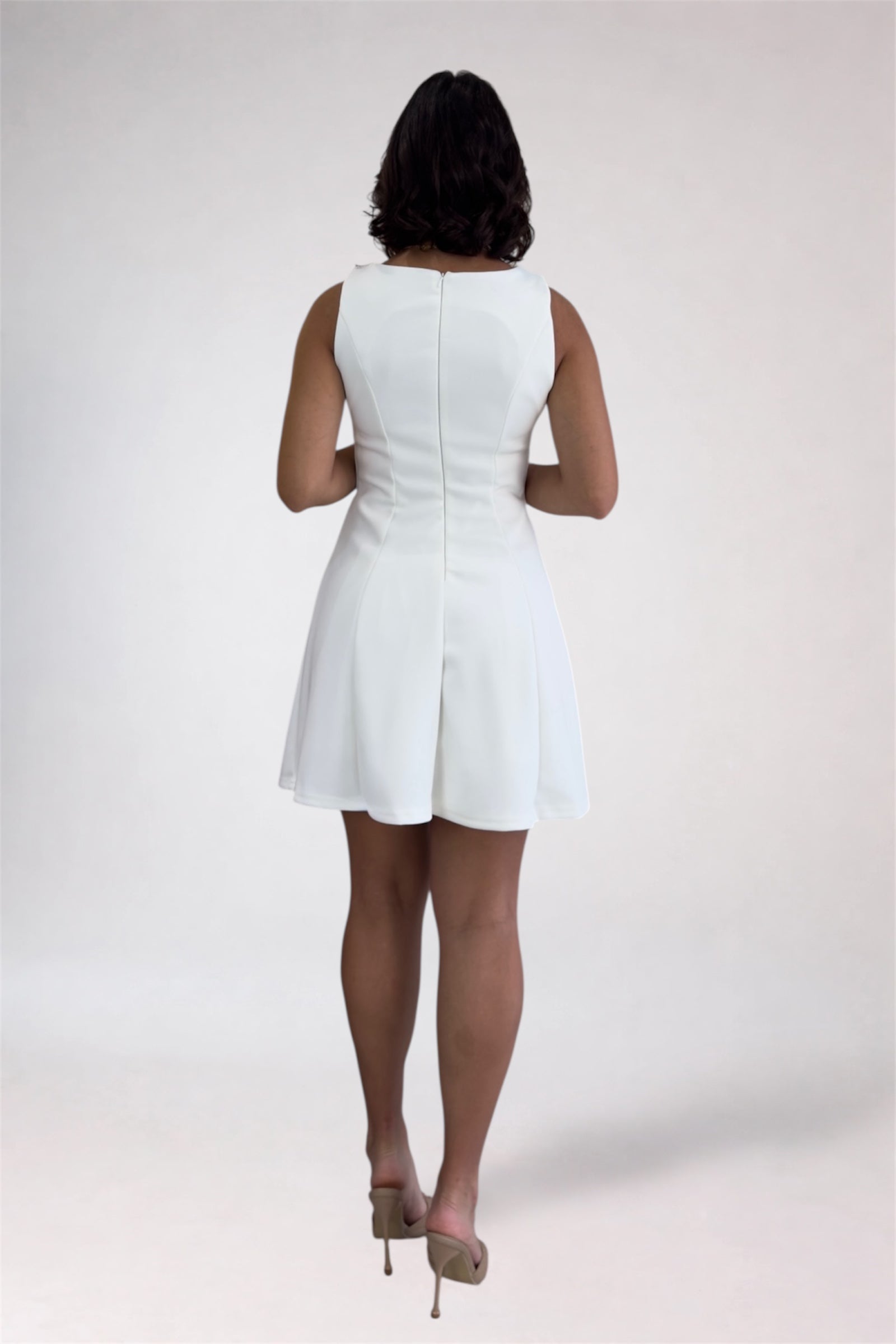 Person wearing a white dress on a plain background