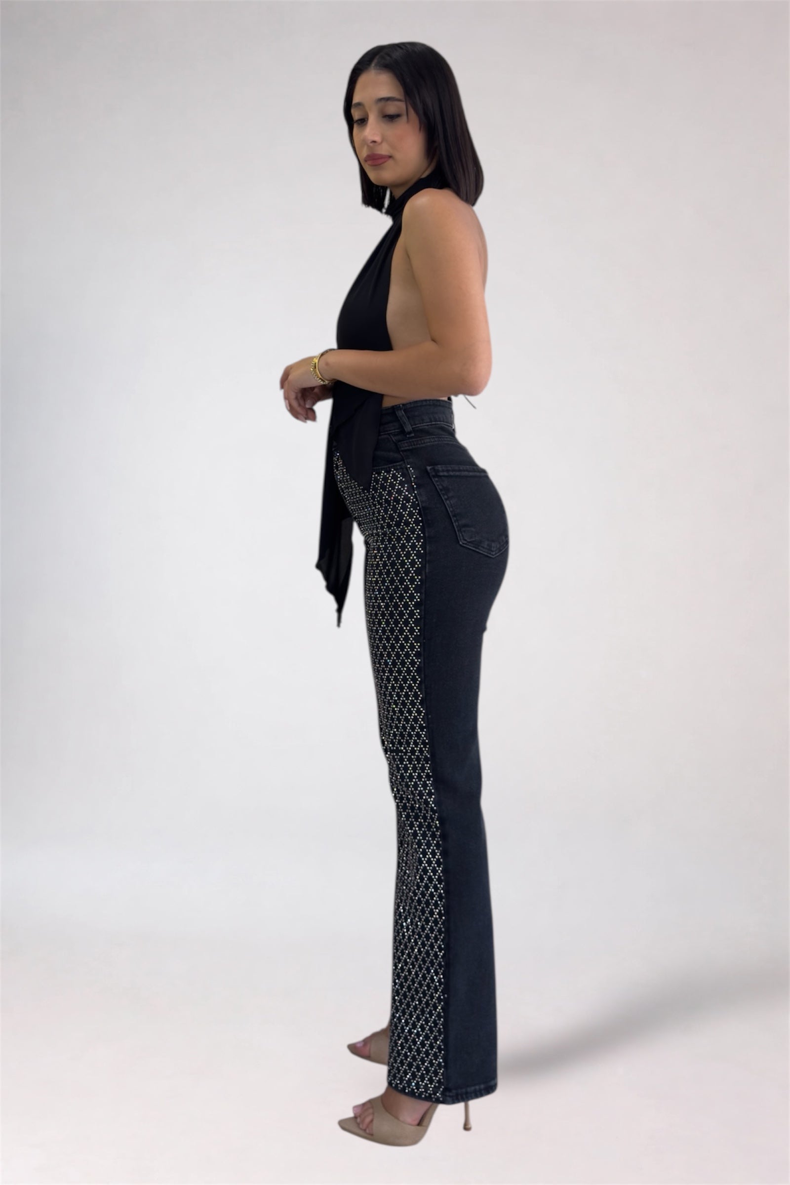 Woman wearing black patterned jeans on a white background