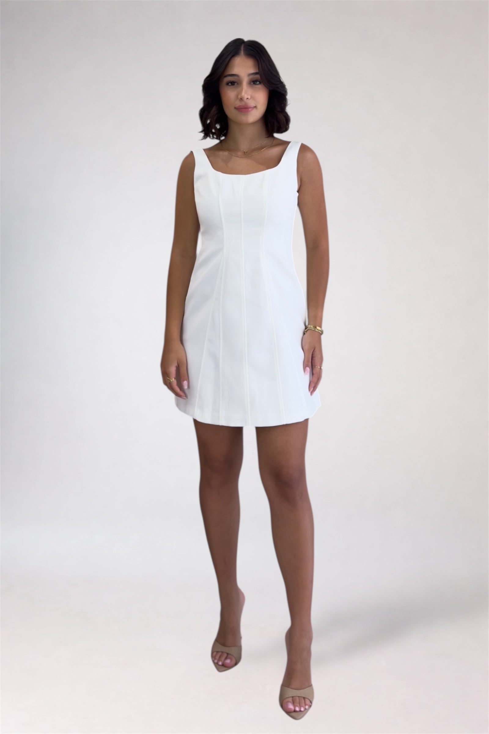 Woman wearing a white dress on a plain background