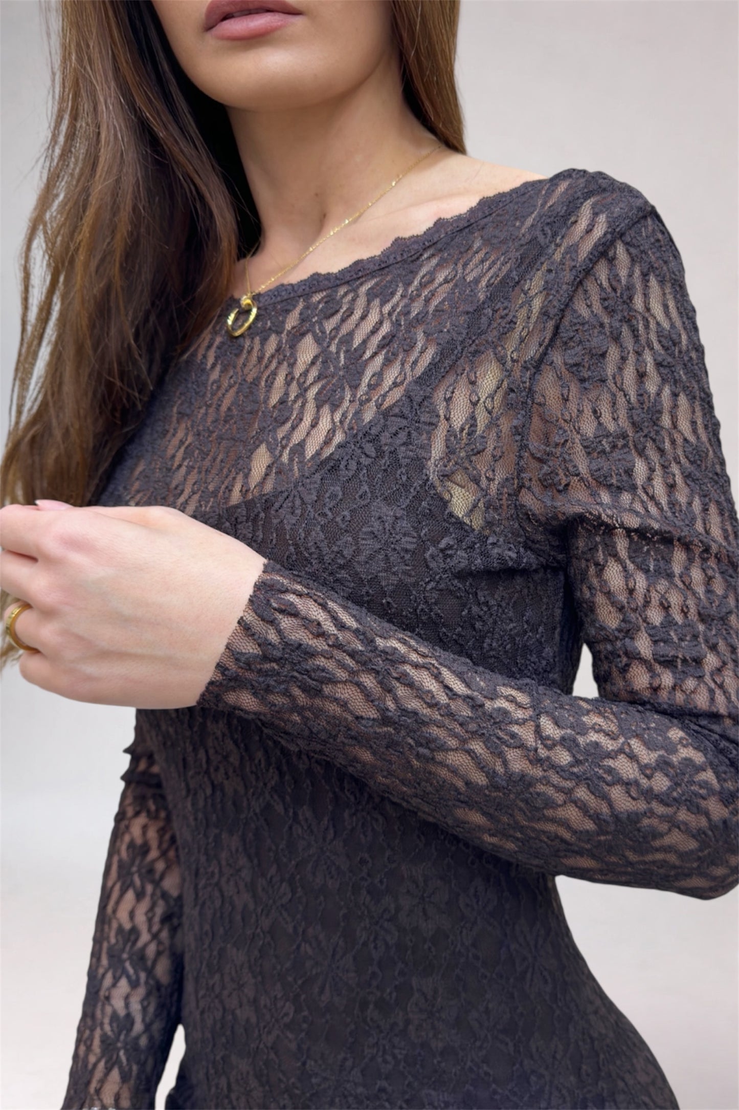 Lace long-sleeve top worn by a person on a plain background
