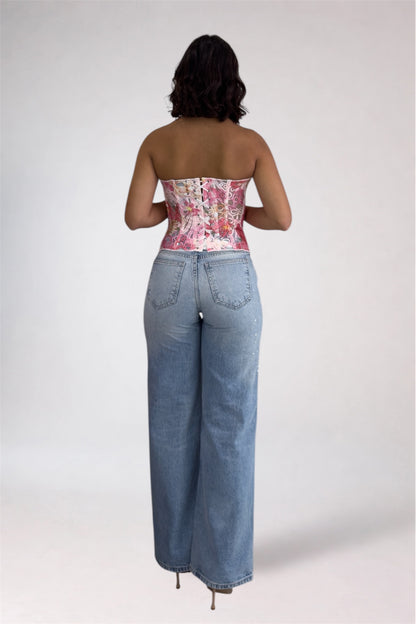 Person wearing a floral strapless top and blue jeans on a white background