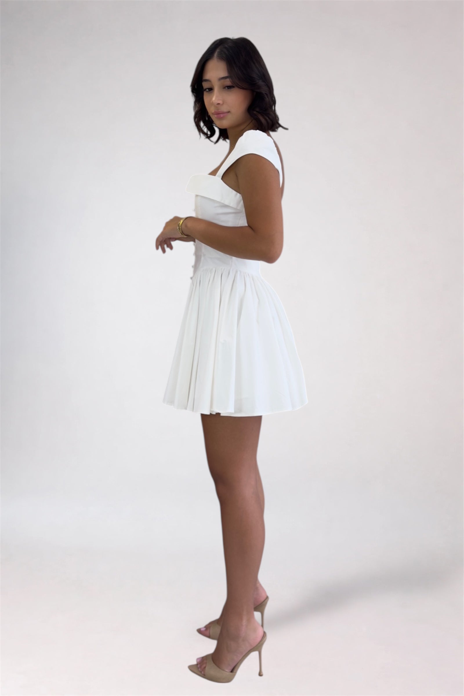 Woman wearing a white dress on a plain background