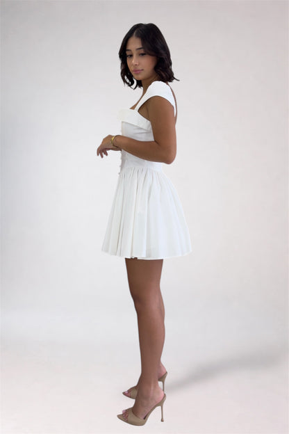 Woman wearing a white dress on a plain background