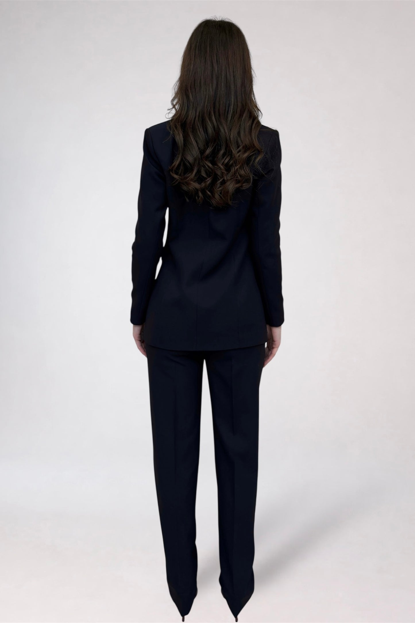 Person wearing a black suit on a white background