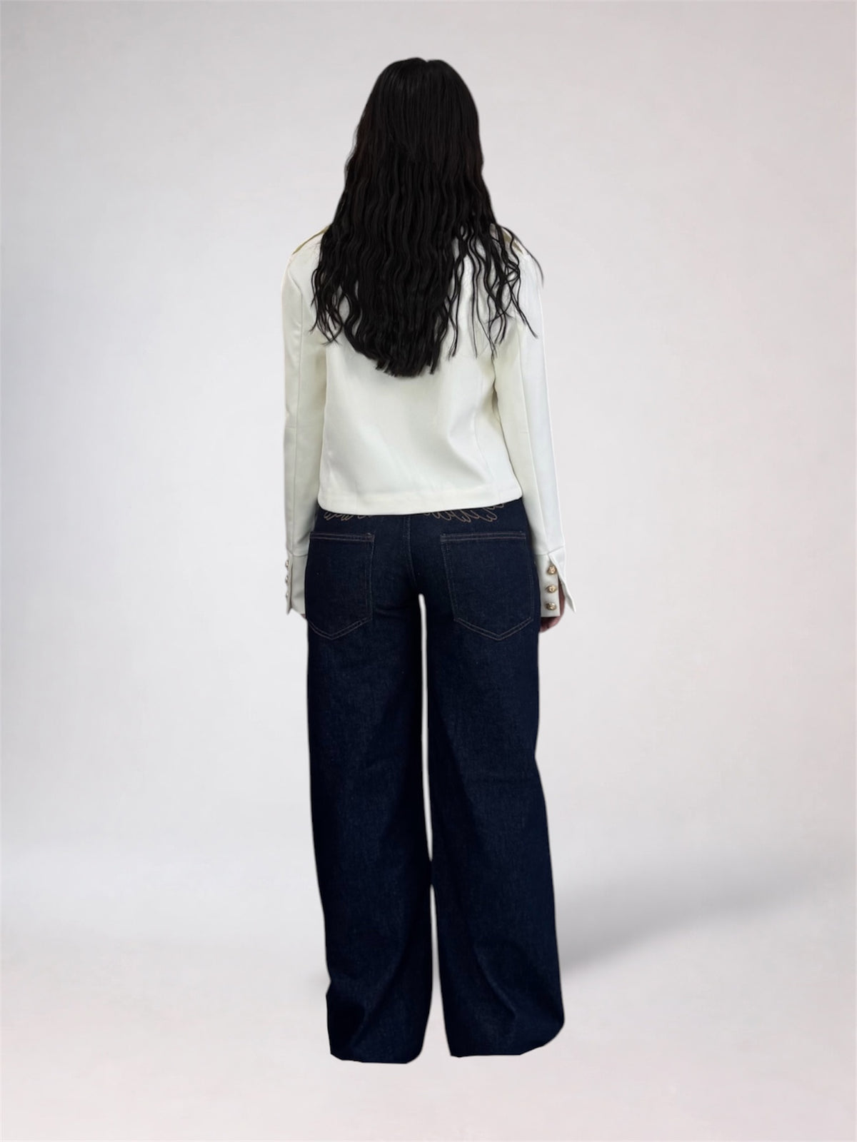 A model shown from the back wearing a white long-sleeve top and dark wide-leg denim jeans against a plain light gray studio background.