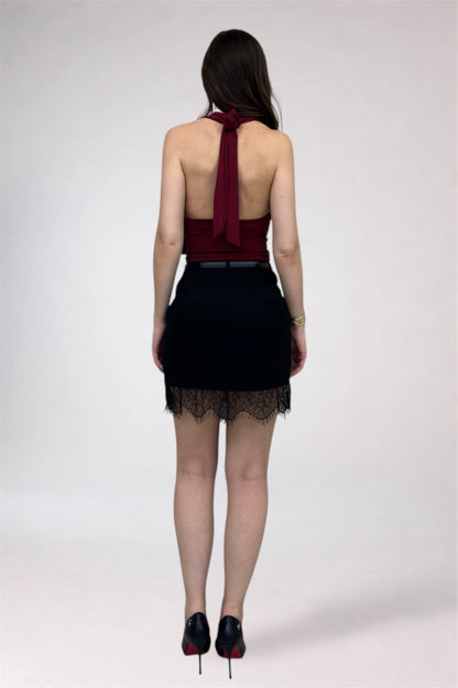 Person wearing a black dress with a red top on a white background