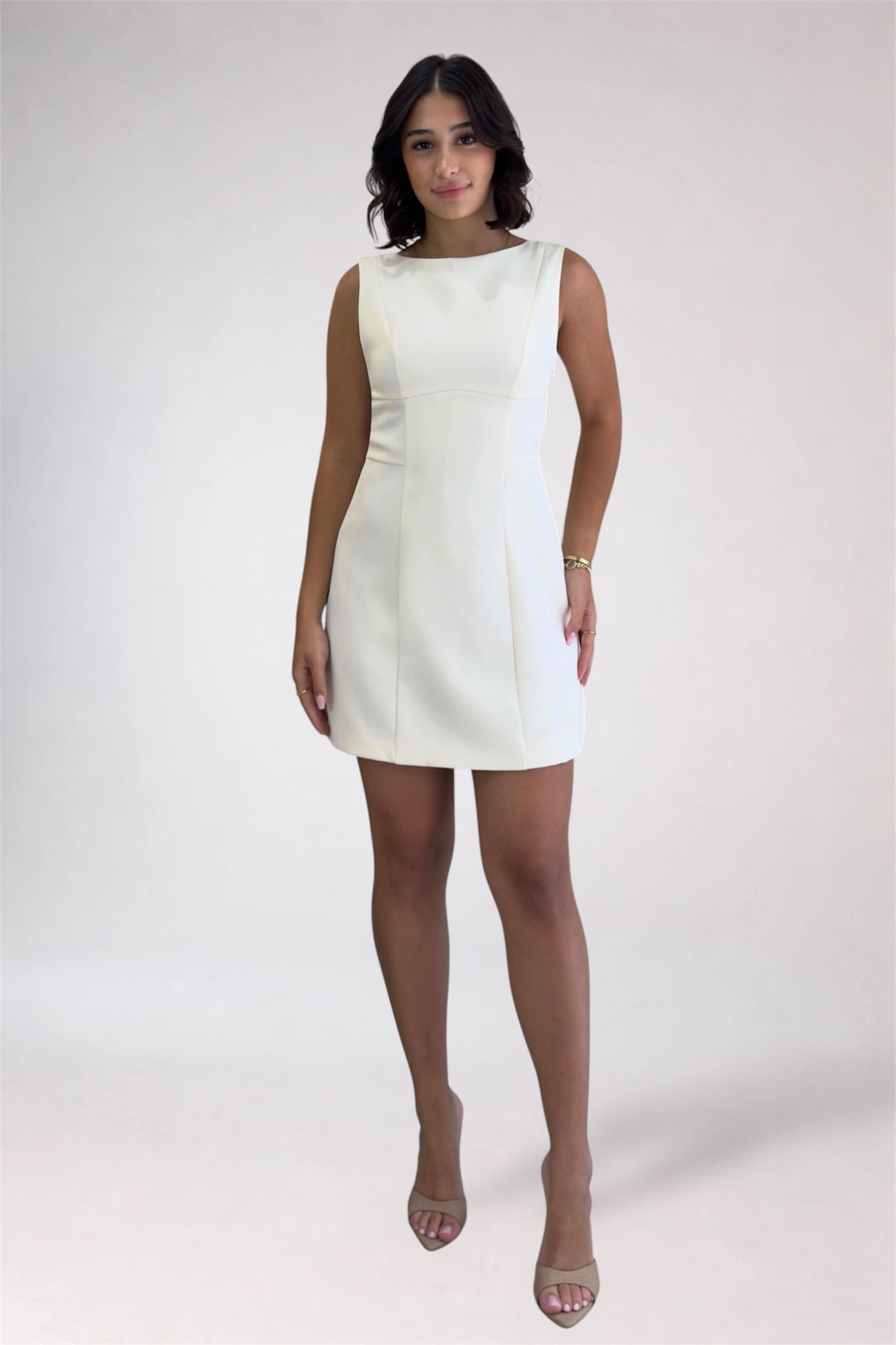 Woman wearing a white dress on a plain background