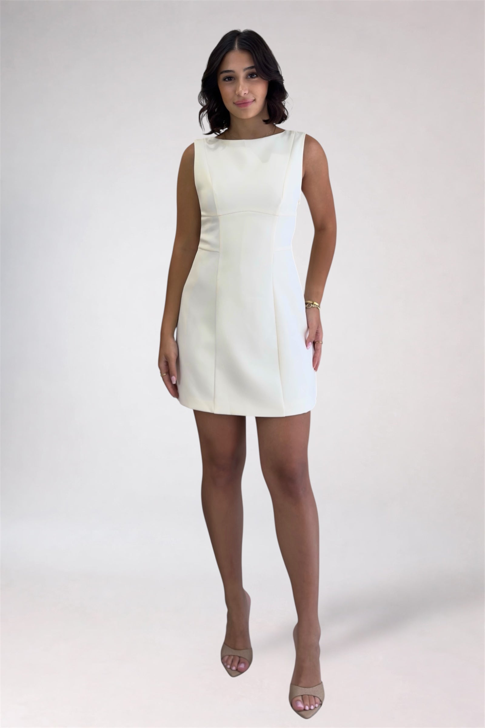 Woman wearing a white dress on a plain background
