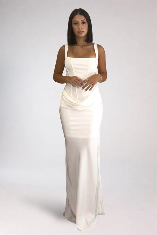 Woman wearing a white evening gown against a plain background