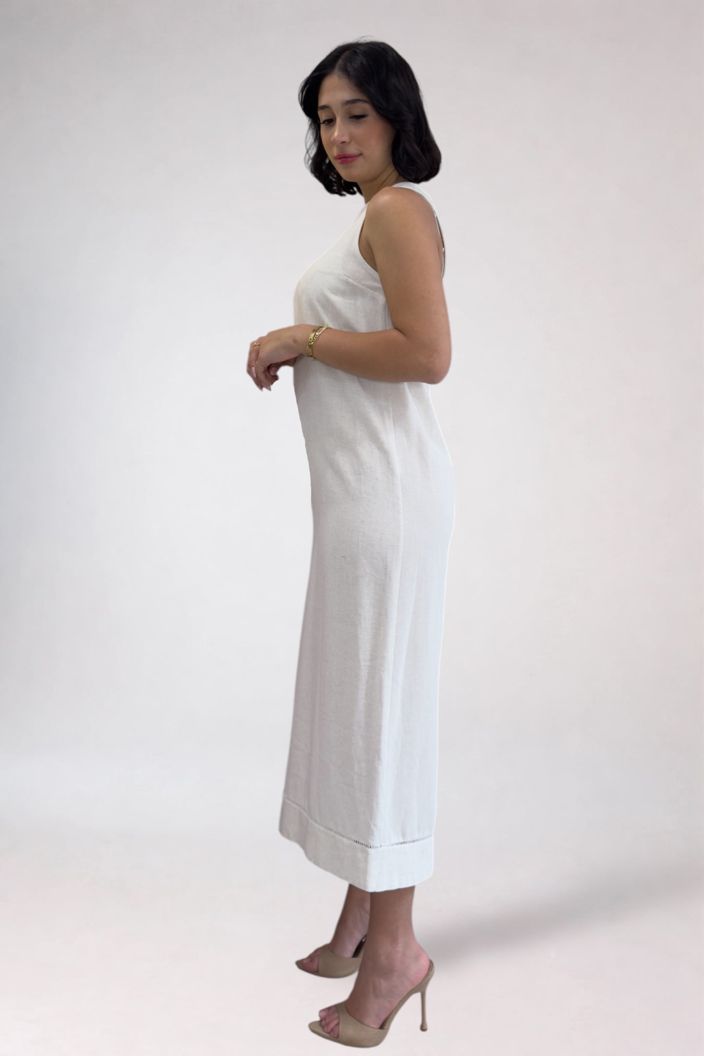 Woman wearing a white dress against a plain background