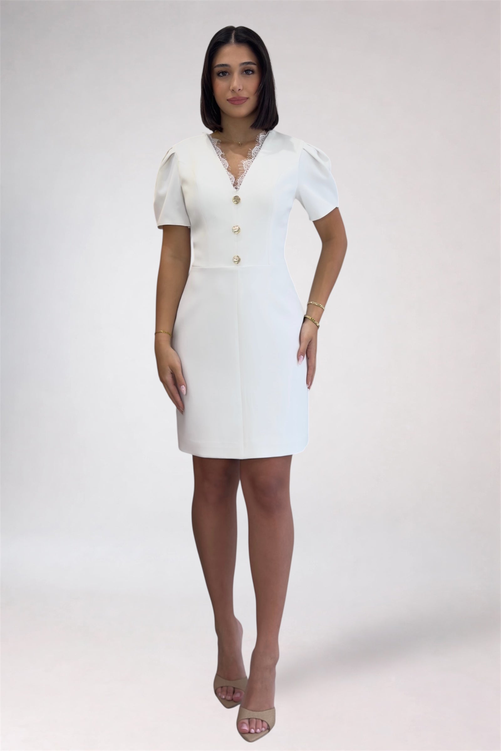 Woman wearing a white dress with buttons on a white background