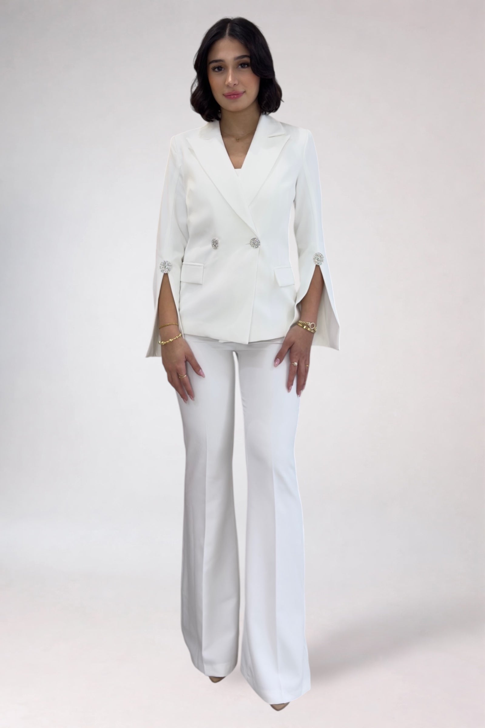 Woman wearing a white suit on a plain background