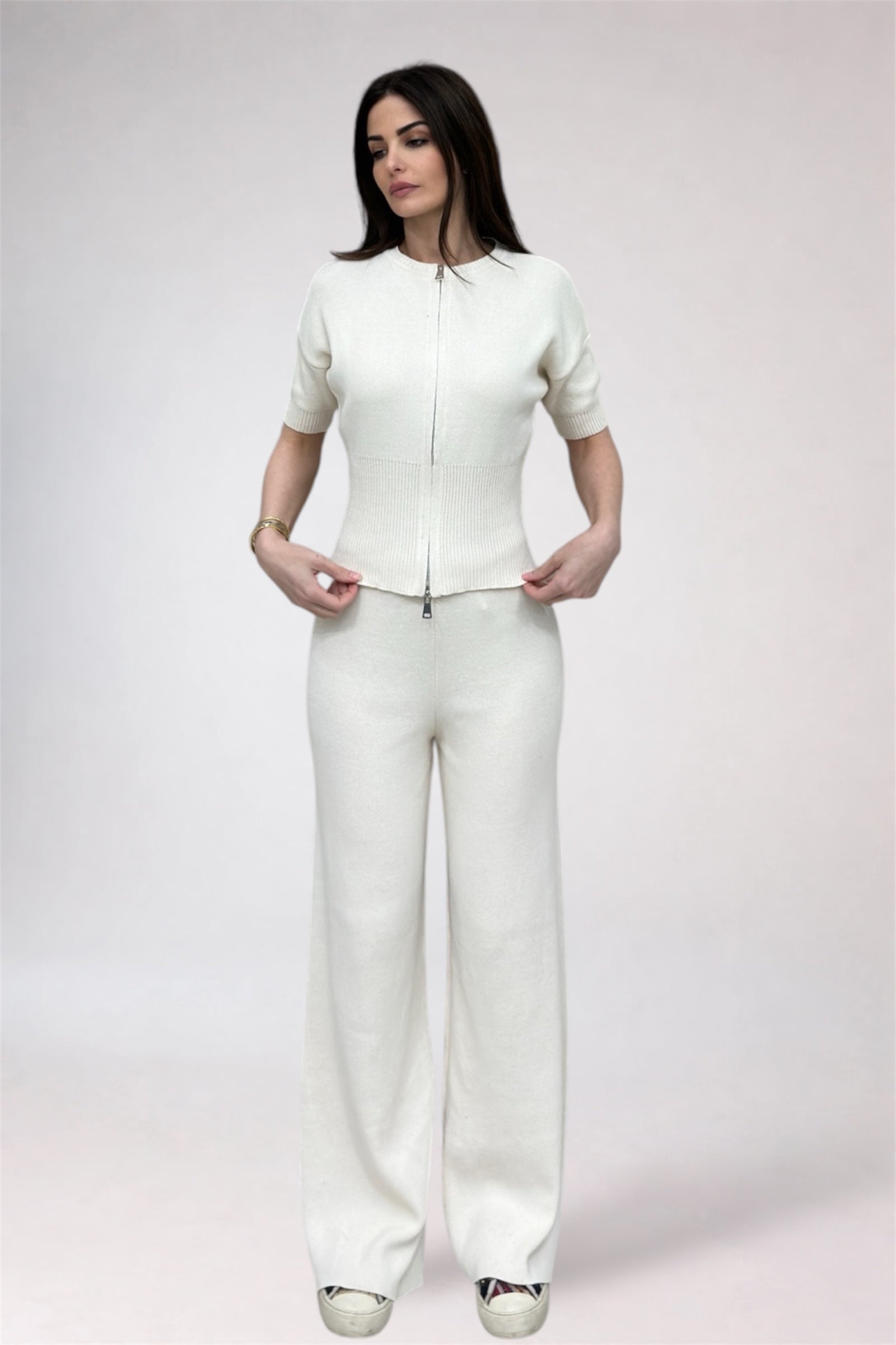 Woman wearing a white outfit on a plain background
