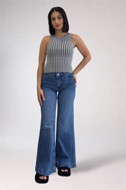 Woman wearing a striped top and blue jeans on a white background