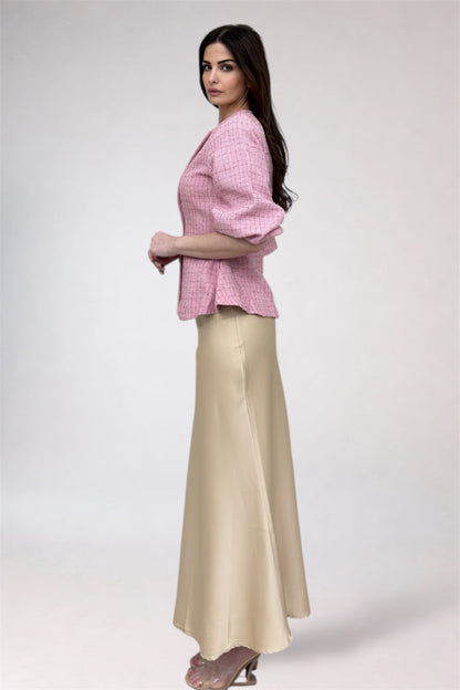 Woman wearing a pink checkered top and beige skirt on a white background