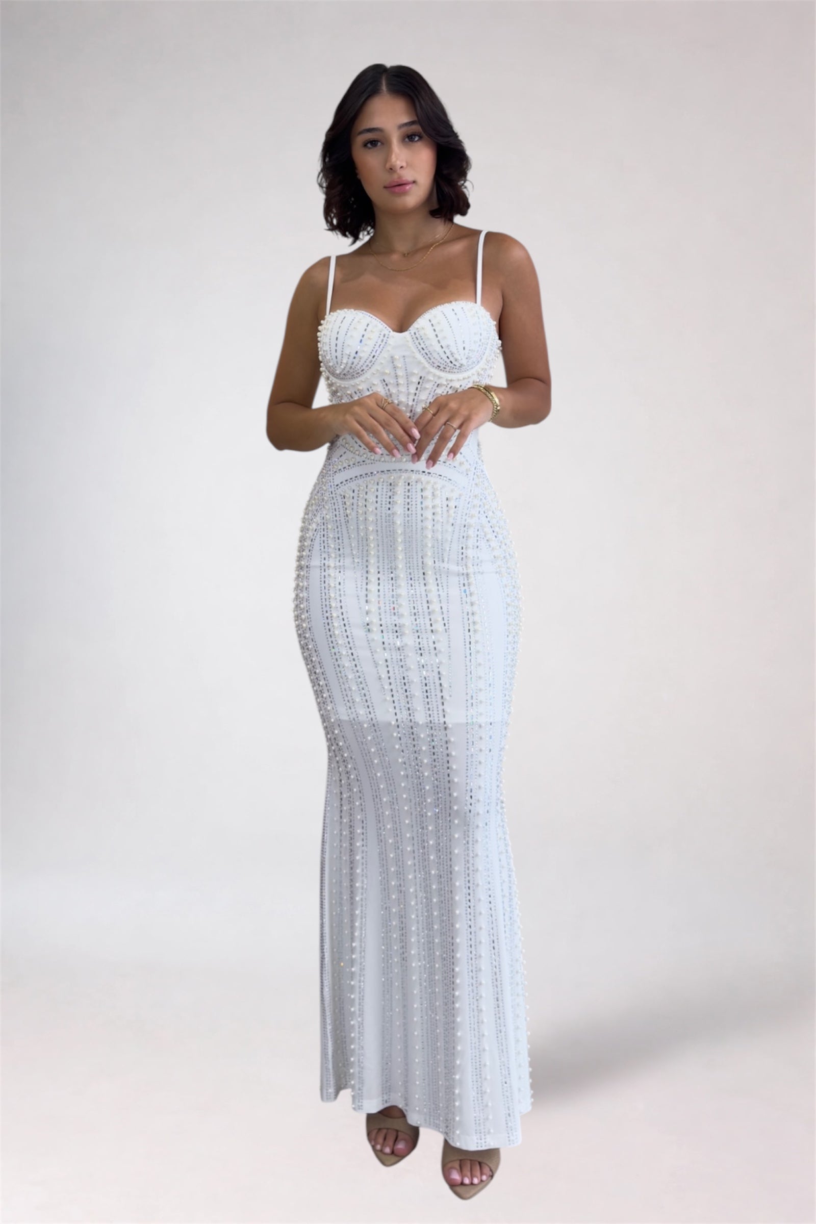 Woman wearing a white lace dress against a plain background