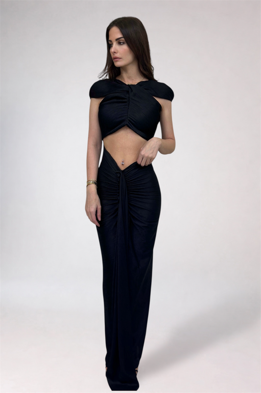 Woman wearing a black outfit with a top and pants on a white background